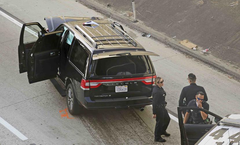 Policías de Los Ángeles después de la persecución de una carroza fúnebre con un féretro y cuerpo al interior en la autopista 110 en el sur de Los Ángeles. (AP/Reed Saxon)