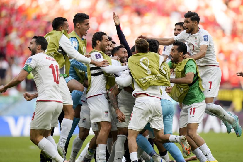 Jugadores de Irán celebran con euforia luego de que Rouzbeh Cheshmi (oculto) anotara el primer gol en los minutos añadidos después que los primeros 90 minutos se agotaron con un empate 0-0 con Gales.
