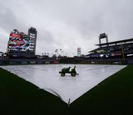 Trabajadores de los Phillies de Filadelfia cubren el campo después de que se anunció que se pospondrá el encuentro de hoy ante los Mets de Nueva York.