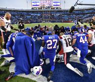 Los jugadores de los Bills de Buffalo y los Patriots de Nueva Inglaterra oran tras su partido en Orchard Park, en Nueva York.