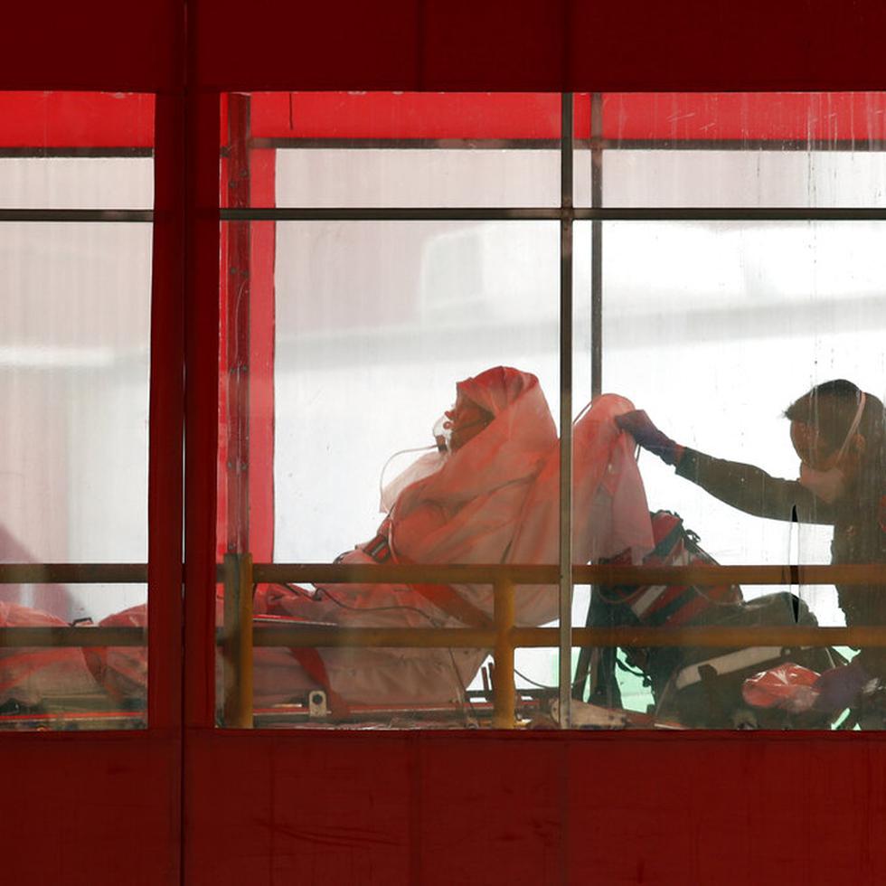 Emergency medical technicians wheel a patient into Elmhurst Hospital Center's emergency room, Tuesday, April 7, 2020, in the Queens borough in New York, during the current coronavirus outbreak.