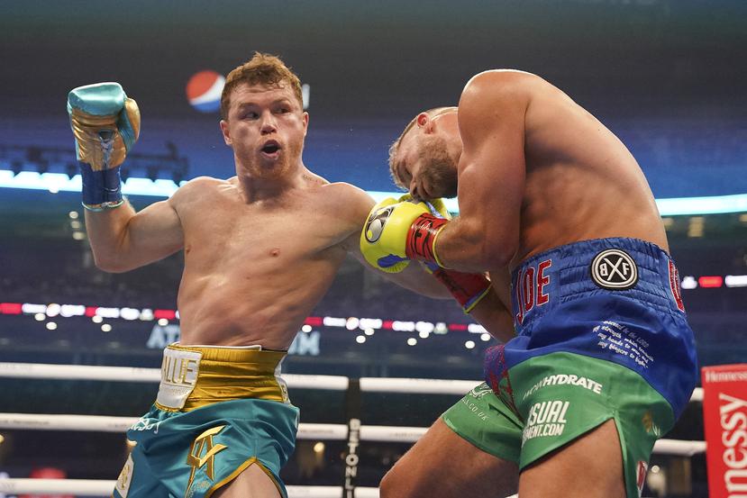 En esta fotografía del 8 de mayo de 2021, el mexicano Saúl "Canelo" Álvarez (izquierda) le pega a Billy Joe Saunders durante una pelea de box en Arlington, Texas.