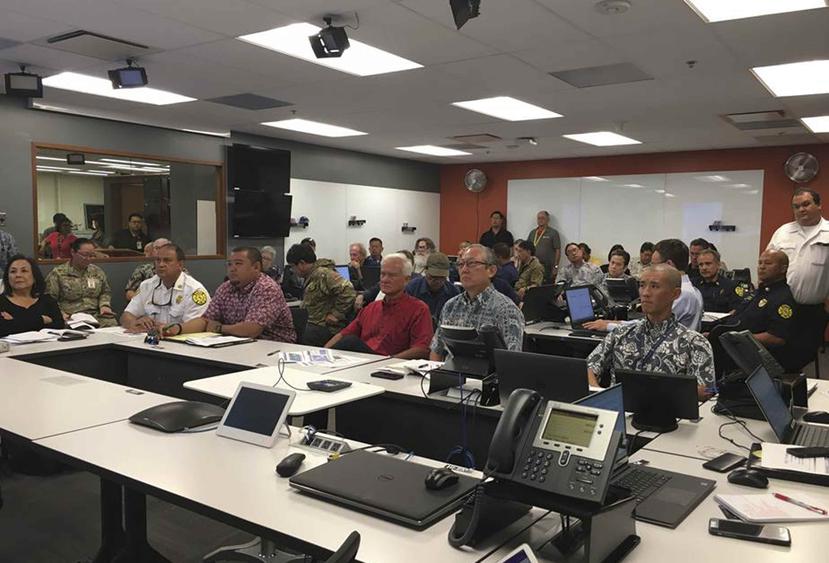 En esta fotografía proporcionada por la municipalidad y condado de Honolulu, el Centro de Huracanes del Pacífico Central informa al alcalde Kirk Caldwell, centro, sobre el huracán Lane en el Centro de Operaciones de Emergencias en Honolulu. (AP)