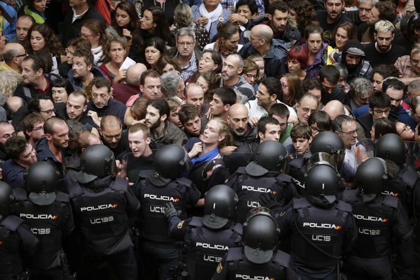 Agentes antidisturbios de la Policía Nacional de España forman un cordón de seguridad en los alrededores del colegio Ramón Llull de Barcelona, para evitar la votación en el referéndum pro independencia . (EFE / Alberto Estévez)