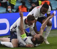 El inglés Harry Kane (en el piso) celebra con sus compañeros de equipo después de anotar el segundo gol de su equipo durante el partido de semifinales de fútbol de la Eurocopa entre Inglaterra y Dinamarca.