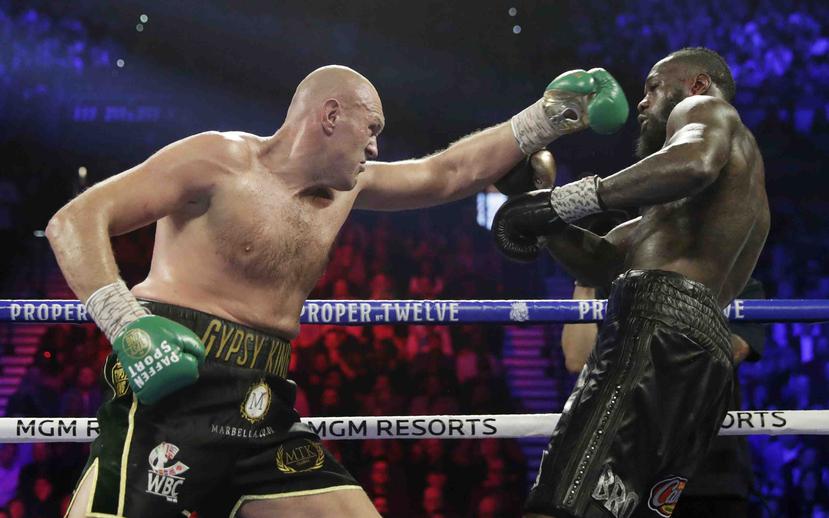 El inglés Tyson Fury, a la izquierda, pelea contra Deontay Wilder por el título de pesos pesados de la WBC. (AP)