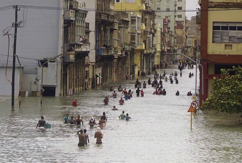 Residentes caminan por una calle inundada de La Habana. (AP)