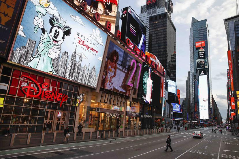 Un policía cruza una séptima avenida vacía en un Times Square escasamente poblado debido al temor a contagio de COVID-19, la tarde del viernes 20 de marzo de 2020, en Nueva York. (AP/John Minchillo)