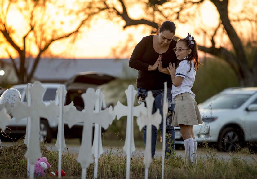 Meredith Cooper, de San Antonio, Texas, y su hija de 8 años, Heather, visitan un lugar de recuerdo creado con 26 cruces de metal cerca de la Primera Iglesia Bautista de Sutherland Springs, Texas, donde murieron 26 personas en un tiroteo. (AP)
