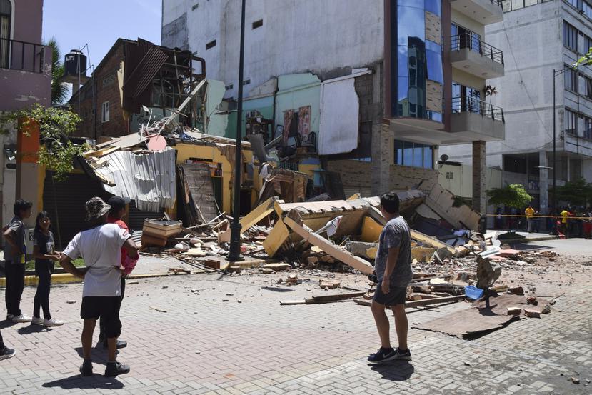 Los residentes miran un edificio que se derrumbó después de que un terremoto sacudiera Machala, Ecuador, el sábado 18 de marzo de 2023. (Foto AP/Jhonny Crespo)