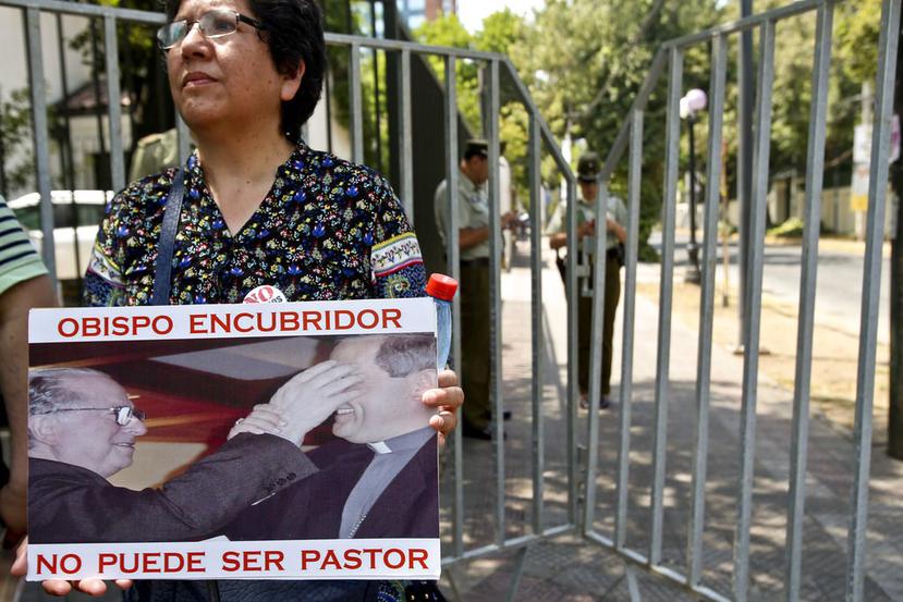 Una mujer miembro del movimiento Laicos de Osorno sostiene una imagen de Juan Barros, con el mensaje "Obispo encubridor no puede ser pastor", durante una manifestación ante la Nunciatura Apostólica en Santiago de Chile (Esteban Félix / AP).