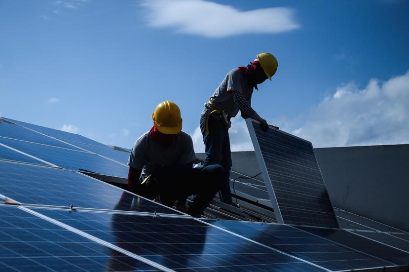 Imagen que ilustra a dos trabajadores instalando placas solares.
