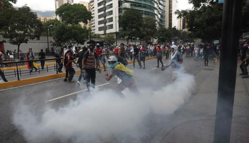 Manifestantes se enfrentan al Policía Nacional Bolivariana durante una protesta contra el presidente de Venezuela, Nicolás Maduro. (EFE)