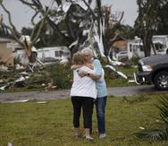 Residentes del parque de casas móviles Century 21 en el área de Iona de Fort Myers, Florida, se abrazan después de que un tornado tocara tierra.