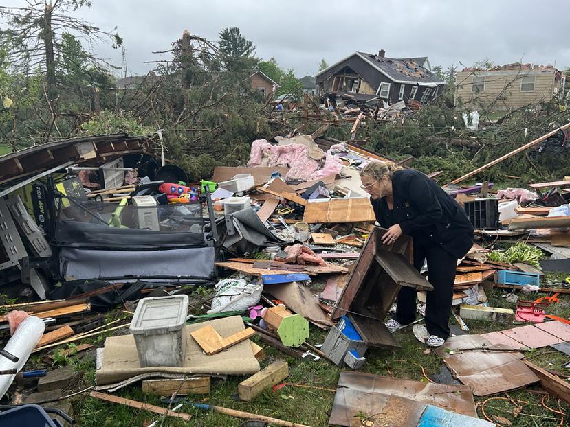 Theresa Haske clasifica los escombros que quedaron en su garaje después de que un tornado arrasara el viernes 20 de mayo de 2022 la comunidad de Gaylord, en el estado de Michigan.