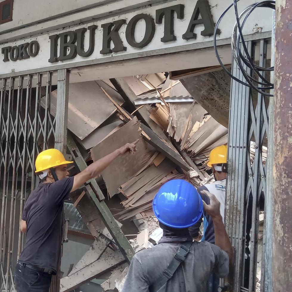 Trabajadores inspeccionan una tienda dañada durante un sismo en Cianjur, Java Occidental Indonesia.
