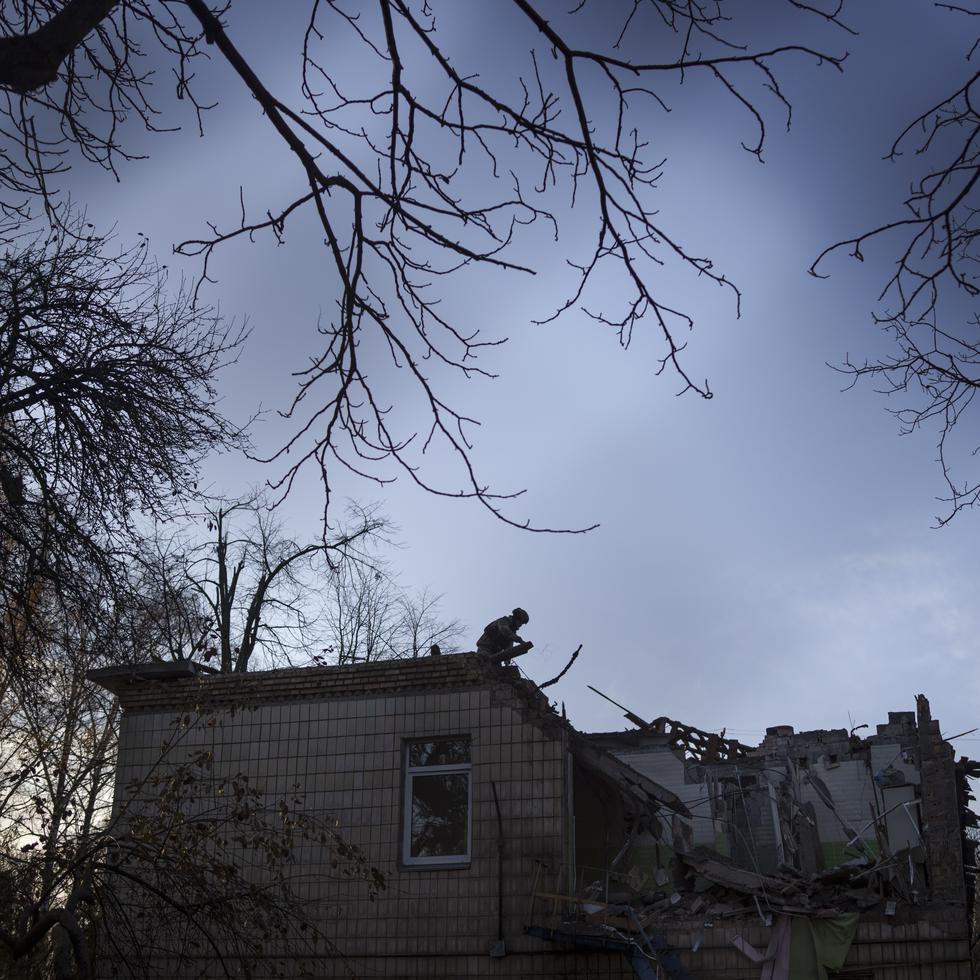 Un soldado ucraniano subió al el tejado de un jardín de infantes que sufrió daños tras un ataque ruso con drones, en Kiev, el sábado.