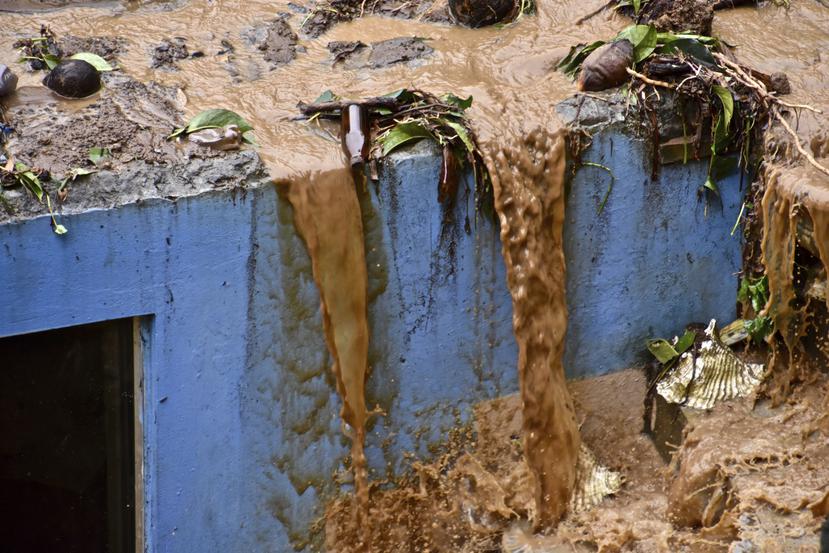 Agua escurre del techo de una casa en Kinsgstown, San Vicente, el jueves 29 de abril de 2021 después de las fuertes lluvias que causaron inundaciones y deslaves en zonas que ya habían sido afectadas por la caída de cenizas de las erupciones recientes del volcán La Soufriere.