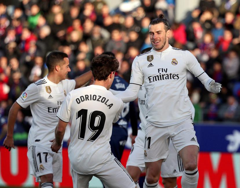 El delantero galés del Real Madrid Gareth Bale (celebra con sus compañeros, Odriozola y Lucas Vázquez  su gol ante el Huesca. (Agencia EFE)