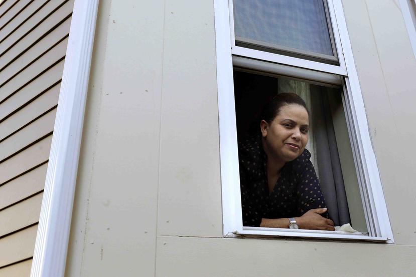 Wendy De Los Santos, originaria de la República Dominicana, posa para una fotografía desde una ventana de su hogar, en Malden, Massachusetts. (AP)