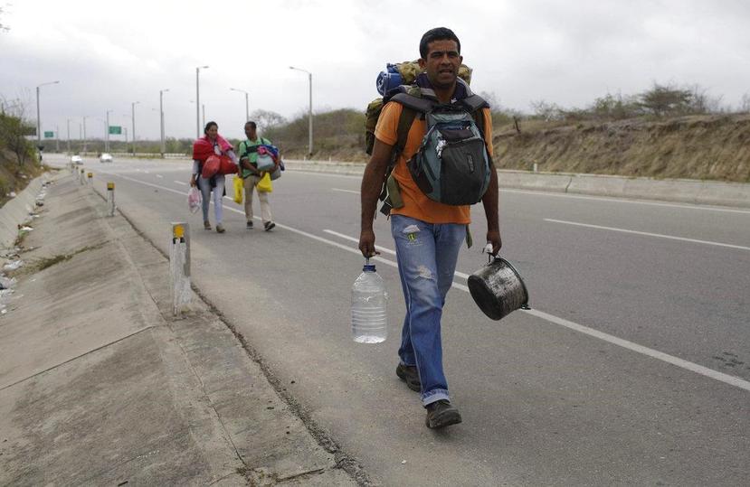 El venezolano Omar Mujica camina rumbo a Lima por la Carretera Panamericana , seguido por otros migrantes venezolanos, tras cruzar la frontera de Ecuador e ingresar a Perú. (AP / Martín Mejía)