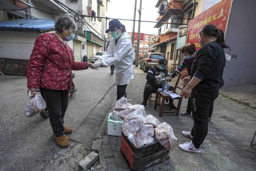 Una mujer compra carne de cerdo en una calle de Wuhan. (AP)
