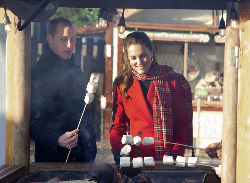 El príncipe William y su esposa Kate rostizan malvaviscos durante una visita a estudiantes en el evento “Navidad en el Castillo” realizado en el Castillo de Cardiff, en Gales. (Foto: AP)