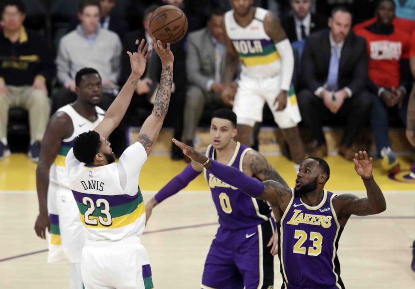 El jugador de los Pelicans de Nueva Orleáns Anthony Davis (izquierda) salta sobre LeBron James (23), de los Lakers de Los Ángeles durante la primera mitad del juego de la NBA que enfrentó a ambos equipos, el 27 de febrero de 2019, en Los Ángeles. (AP)