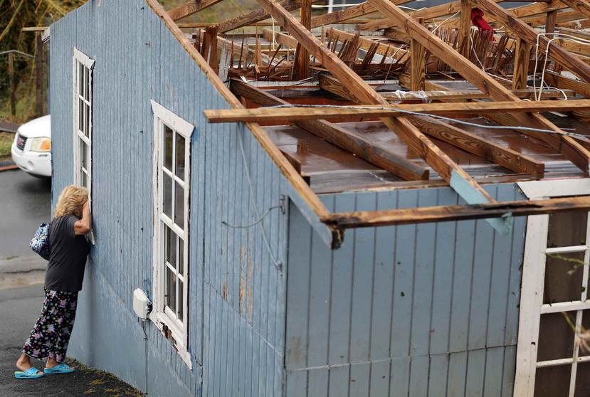 Blanca Esther González mira por una ventana la destrucción que causó el huracán María en su residencia en Cidra. (Archivo / GFR Media)