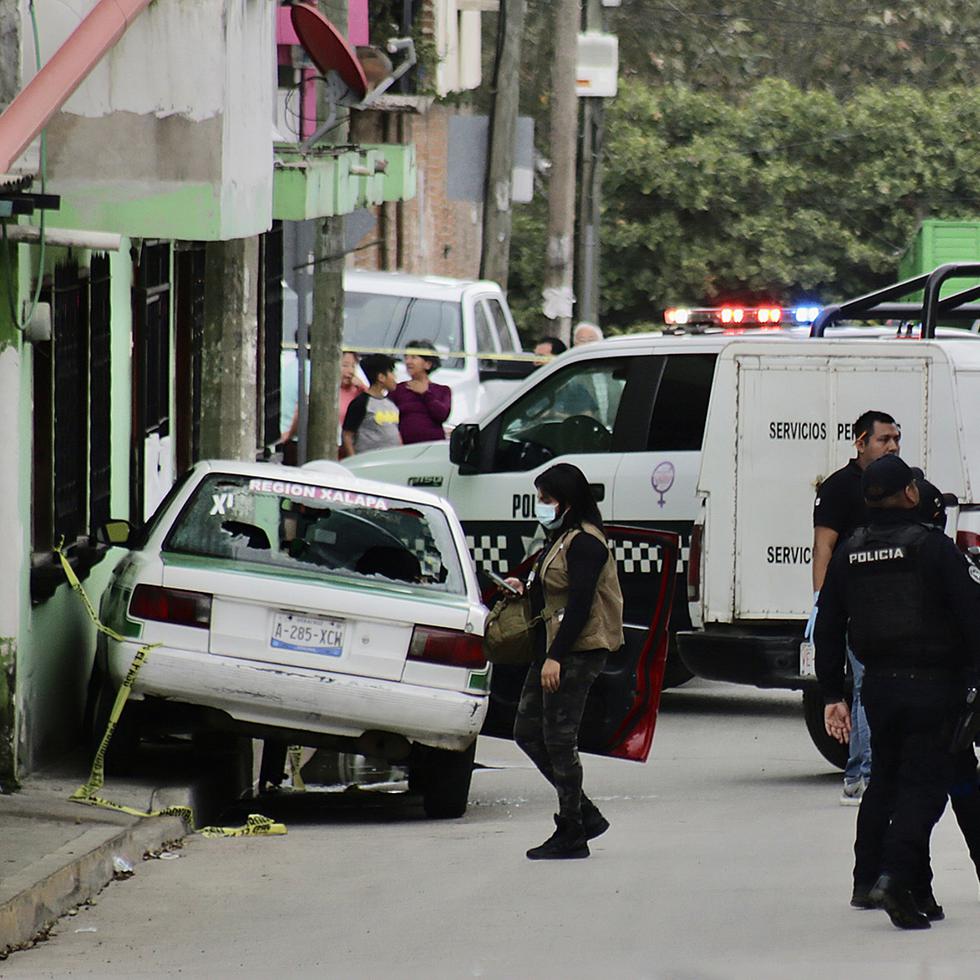 Miembros de la policía municipal y agentes periciales inspeccionan una escena del crimen donde fue asesinado el periodista mexicano Pedro Pablo Kumul, en Xalapa, Veracruz.