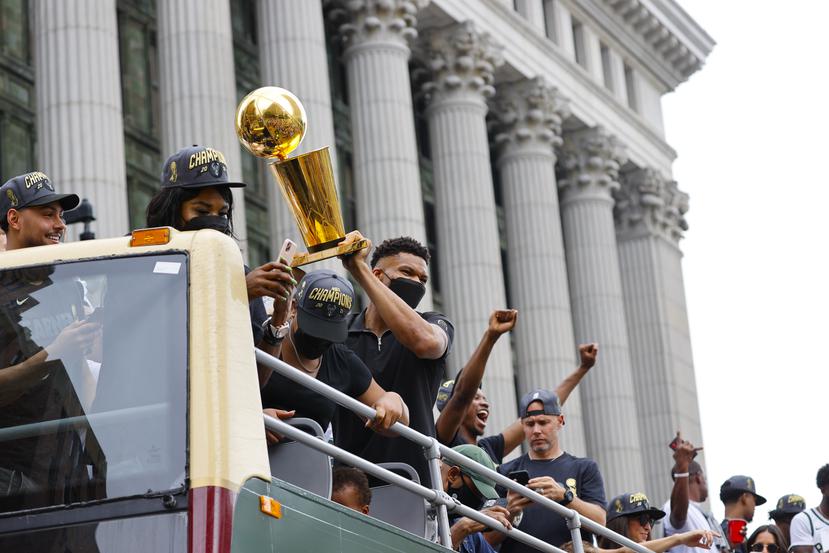 Giannis Antetokounmpo alza el trofeo de campeonato de la NBA durante la parada d los Bucks en la ciudad de Milwaukee.