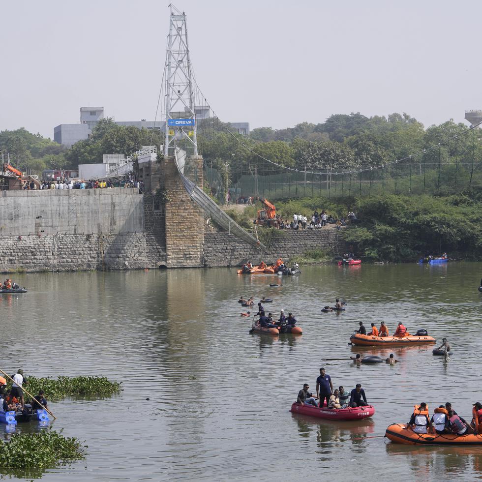 Rescatistas en botes buscan a personas en el río Machchu debajo de un puente que se vino abajo dejando al menos 134 personas muertas.