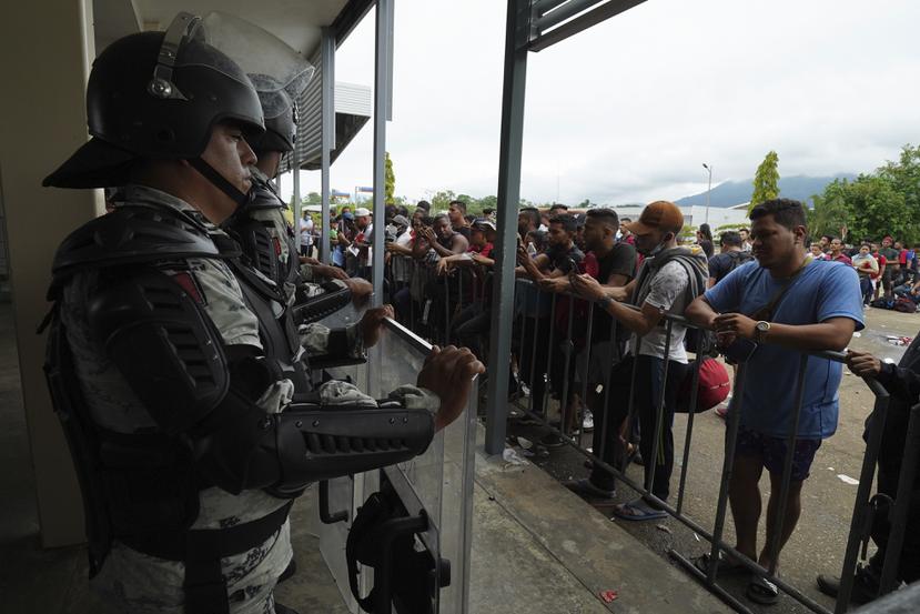 Migrantes se reúnen afuera del Centro de Atención Integral de Tránsito Fronterizo, custodiado por fuerzas de seguridad, para pedir documentos legales que les permitan viajar por México.