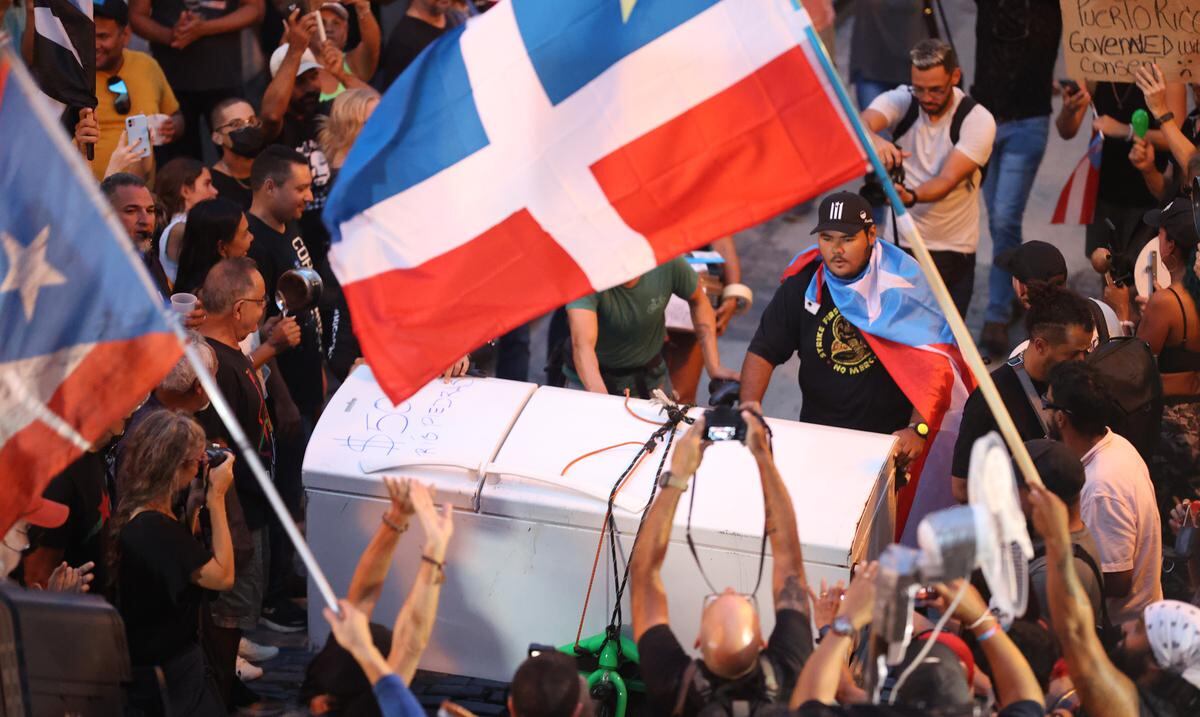 Protesters carry items damaged by the blackout and power surges to Old San Juan