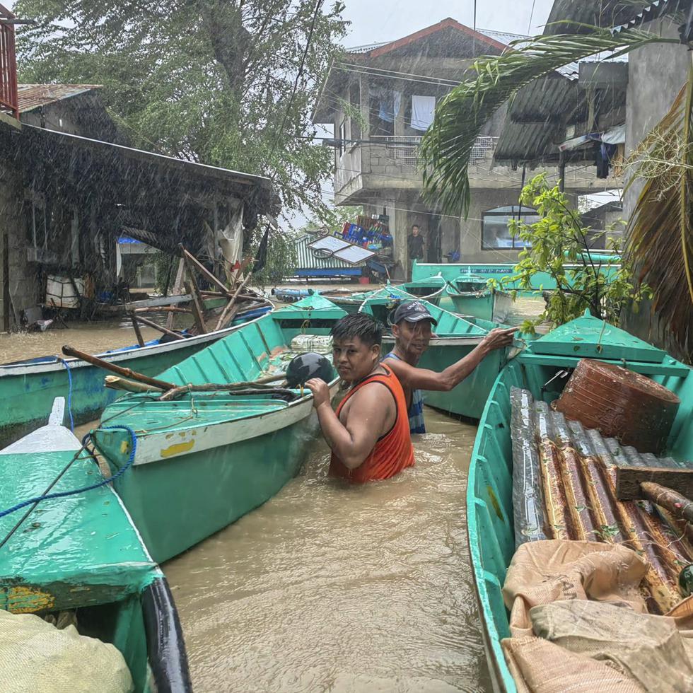 Residentes toman sus botes para evitar que sean arrastrados por las crecidas de un río, tras el paso del tifón Doksuri, en la ciudad de Laoag, en la provincia de Ilocos Norte, en Filipinas, el miércoles 26 de julio de 2023.