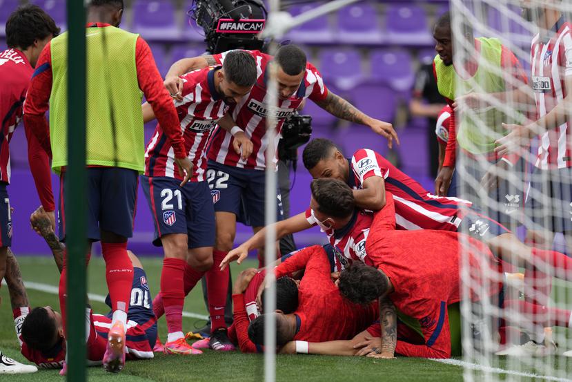Los jugadores del Atlético de Madrid celebran con Luis Suárez luego que éste anotó el segundo gol del Atlético de Madrid en la victoria 2-1 contra Valladolid y que aseguró al equipo el campeonato del torneo nacional.