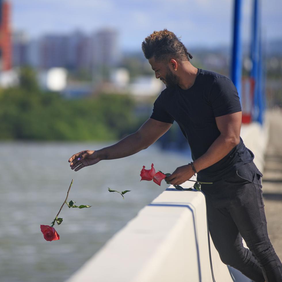 Un hombre suelta una flor en la laguna San José desde el puente Teodoro Moscoso, lugar donde fue encontrado el cuerpo de Keishla Rodríguez Ortiz.