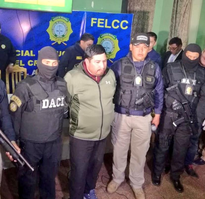 El presunto autor del robo de las piezas presidenciales, Alexander Fernando Huañocaña Arenas, es escoltado por oficiales de la Policía de Bolivia. (Fuente / Twitter Policía de Bolivia)