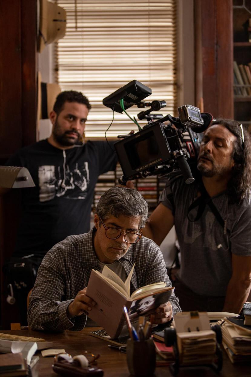El director fotográfico Sonnel Vázquez sostiene la cámara mientras el actor Esai Morales, quien interpreta al profesor en la película, lee en su despacho.(Suministrado)
