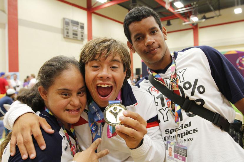 Heriberto Torres celebra su medalla de oro en los 100 metros pecho junto a Eneida Torres y Luis Pena Bosch, durante los Juegos Mundiales de Olimpiadas Especiales.