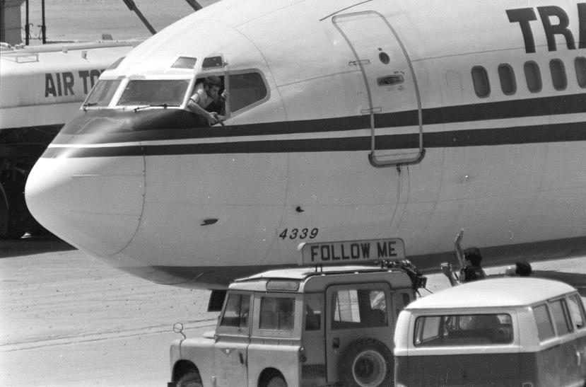 Un secuestrador apunta su arma hacia el equipo de noticias de la cadena estadounidense ABC desde la ventana de la cabina del avión de Trans World Airlines. (AP/Herve Merliac)