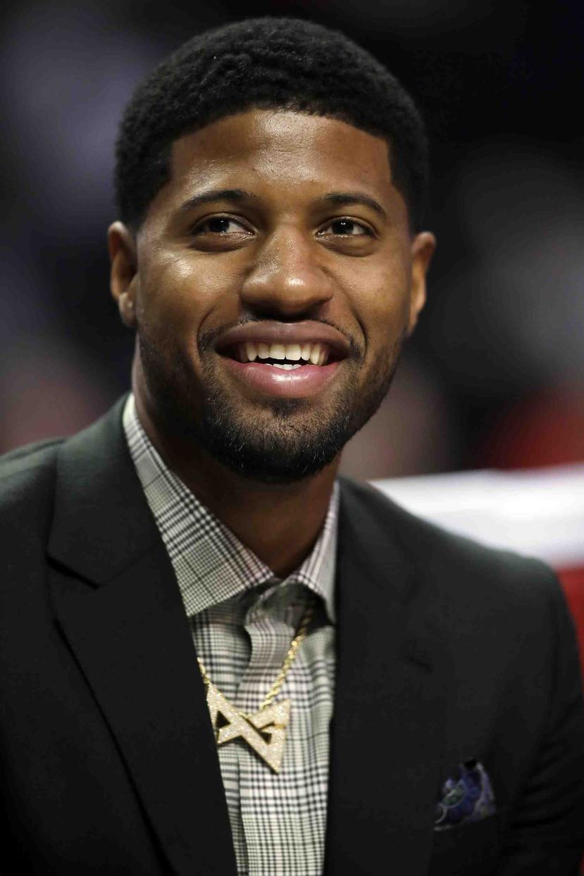 Paul George sonríe en la banca durante un partido de los Clippers. (AP)