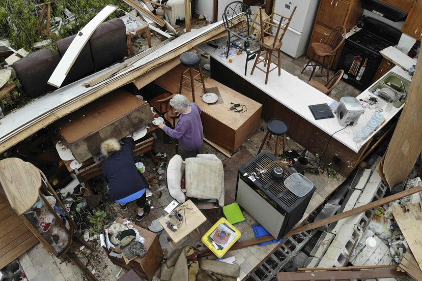 Un par de personas busca entre sus pertenencias en un hogar destrozado tras el paso de un tornado este lunes en Chatsworth, Georgia. (AP)