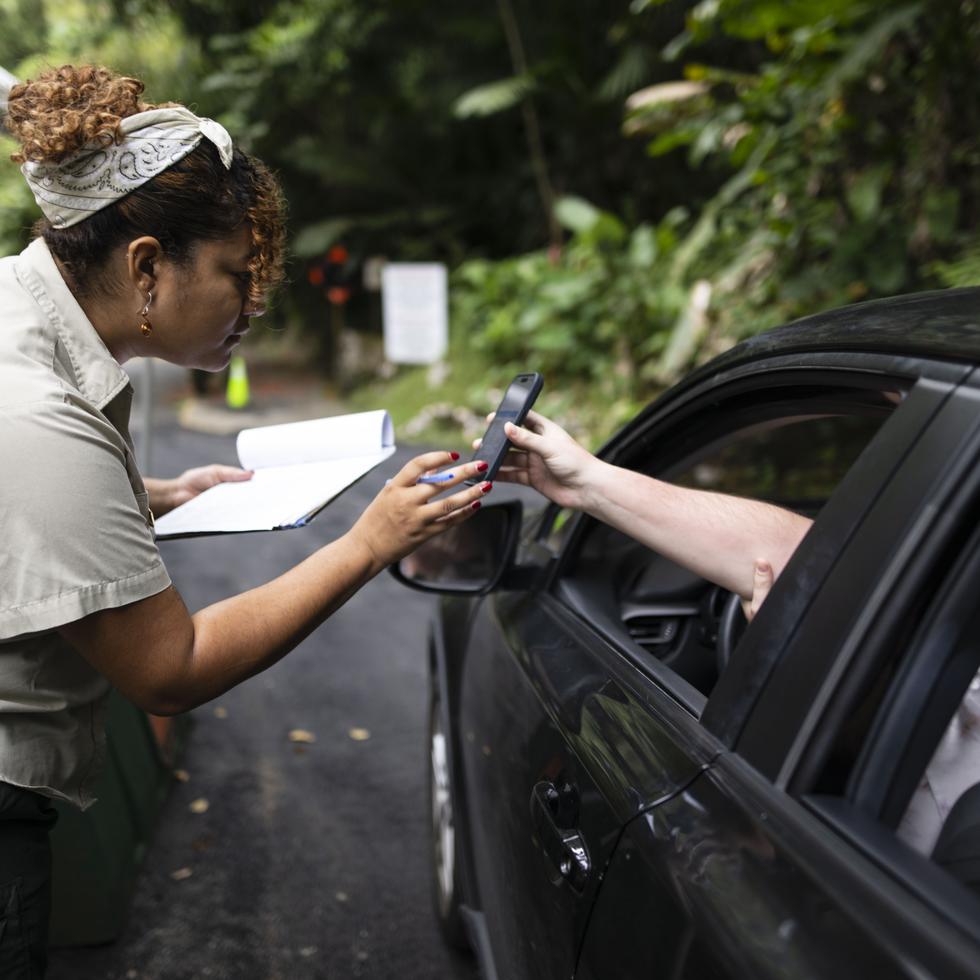 Una empleada del Servicio Forestal de Estados Unidos se encarga de validar la reservación u orientar al visitante que no tiene reservación acerca de cómo completar el proceso.