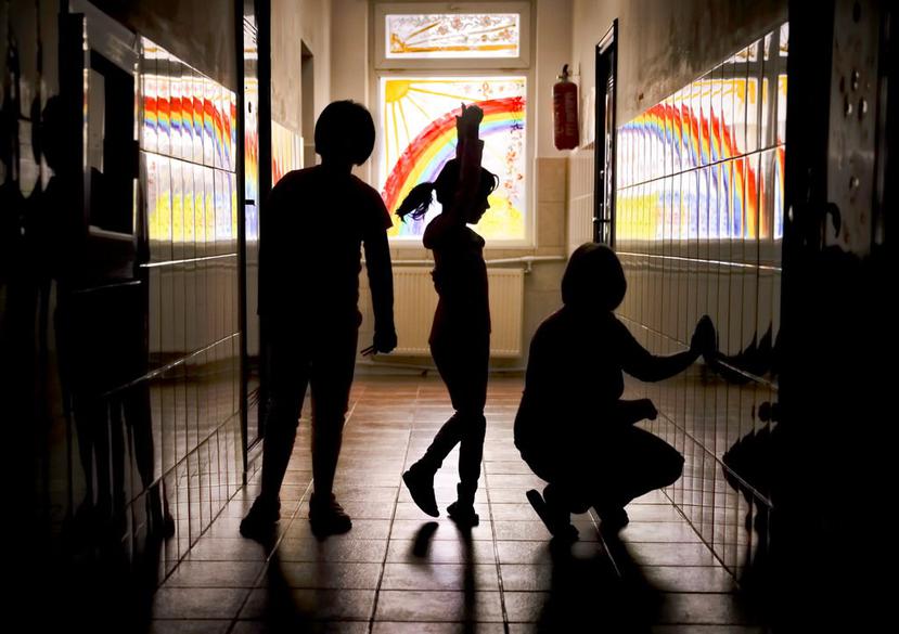 Sara, una niña que vive en el orfanato Robin Hood, intenta bailar ballet mientras posa para una foto con otros niños en un pasillo con las ventanas pintadas, en Bucarest, Rumania (AP).