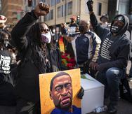 Cortez Rice, left, of Minneapolis, sits with others in the middle of Hennepin Avenue on Sunday, March 7, 2021, in Minneapolis, Minn., to mourn the death of George Floyd a day before jury selection is set to begin in the trial of former Minneapolis officer Derek Chauvin, who is charged in Floyd's death. (Jerry Holt/Star Tribune via AP)