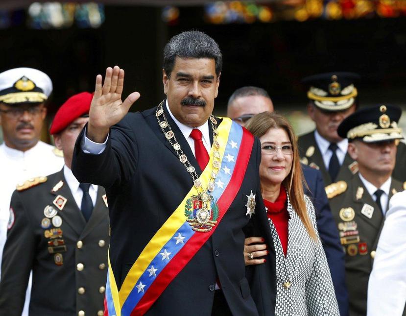 Nicolás Maduro y su esposa, Cilia Flores, saludan a su llegada a un desfile militar en el Fuerte Tiuna en Caracas. (AP)