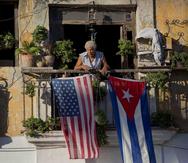 Javier Yáñez está parado en su balcón de La Habana decorado con las banderas de Estados Unidos y Cuba. (AP / Ramón Espinosa)