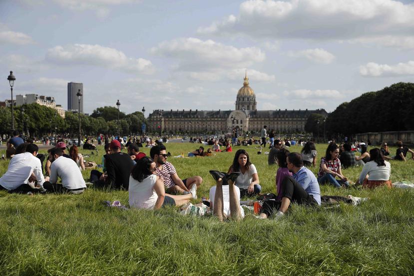 En París, un grupo de personas descansa en los bordes del Jardín de las Tullerías. (AP)
