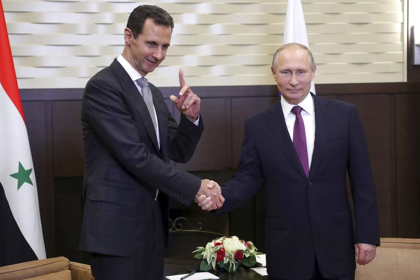 Vladímir Putin y Bachar al Asad se saludan al inicio de la reunión en Sochi, Rusia (AP).